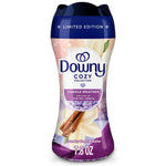 Close-up of a Downy Cozy Collection Cuddle Weather laundry scent booster bottle with purple cap and decorative cinnamon and vanilla graphics.