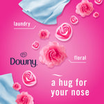 Graphic of pink roses, a blue cloth and Downy logo on a pink background with the phrase ‘a hug for your nose’
