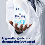 Person in a lab coat holding a bottle of Downy Ultra Free & Gentle fabric conditioner with 'hypoallergenic' messaging.