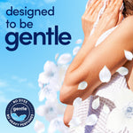 Close-up of a person holding a towel with floral petals and copy reading 'designed to be gentle'