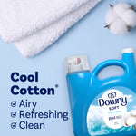 Flat lay of a Downy Soft Cool Cotton jug next to white towels and a cotton boll on a pale blue background