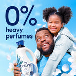 Father and child smiling with a Downy Light bottle and large text '0% heavy perfumes' in the background