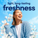 Smiling woman in a blue sweater against a sky background with text promoting light, long-lasting freshness