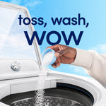 Hand pouring white scent beads into a top-loading washing machine with copy toss, wash, wow