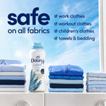 Downy Light bottle on a laundry surface flanked by neatly folded blue and white clothing and safe-on-all fabrics text