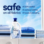 Downy Light bottle displayed on a washer with folded laundry and text claiming it's safe on all fabrics