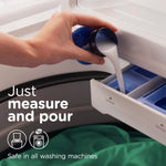 Hand pouring liquid fabric softener from a blue cap into a washer dispenser with usage text