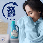 Woman smelling a towel with a Downy Soft Cool Cotton bottle and '3X longer lasting scent' text