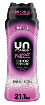 Tall bottle of Downy Unstopables Fusions Sunrise + Nectar laundry scent booster with pink and black label and visible beads at base