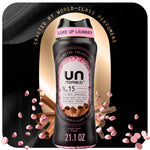Black bottle of Downy Unstopables N.15 scent beads with pink beads and cinnamon accents on a dark background