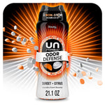 Close-up stylized bottle of Downy Unstopables Odor Defense Sunset + Citrus with orange and white scent beads bursting outward
