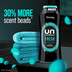 Downy Unstopables Fresh bottle beside stacked teal towels with '30% MORE scent beads' callout