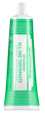 Close-up of a green Dr. Bronner's spearmint All-One toothpaste tube showing label text and cap