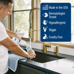 Person pouring soap into a bottle at a kitchen sink with a benefits panel listing Made in the USA, Dermatologist Tested, Hypoallergenic, Vegan, and Cruelty Free