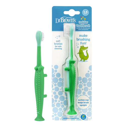 Dr. Brown's green crocodile toddler toothbrush shown loose beside its blister-pack backing with product graphics and blue bubble design.