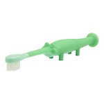 Angled close-up of a green crocodile toddler toothbrush showing head, textured body and suction-cup tail on white background.