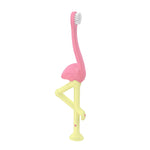 Close-up product shot of Dr. Brown’s pink flamingo toddler toothbrush showing pink curved head and yellow angled leg-shaped handle