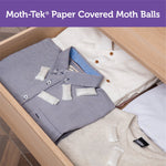 Drawer of folded shirts with small white moth ball packets placed on top of garments