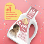 Angled Dreft baby detergent bottle on pink background with promotional badge and baby image