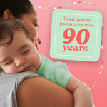 Mother holding a sleeping baby against a pink background with a badge that says ‘Used by new parents for over 90 years’.