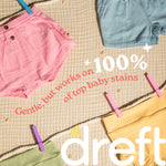 Flat lay of pastel baby clothing clipped to a rope with text claiming it works on top baby stains