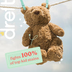 Brown teddy bear hanging on a clothesline against a cloudy sky with text claiming ‘fights 100% of top kid stains’.