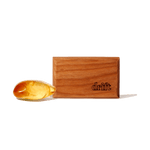 Wood rectangular Drift car freshener block with visible logo beside a piece of amber-like resin on a white background.