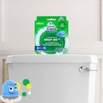 Lifestyle-style photo of Scrubbing Bubbles Drop Ins box displayed on a white toilet tank with mascot graphic at corner