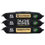 Three stacked black DUDE Wipes packets with XL label, plant sourced fibers badge and central brand panel