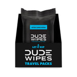 Display box of multiple black Dude Wipes travel packs showing front pack with 'Let It Rip' and travel packs text on box