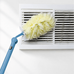 Yellow fluffy duster head cleaning a dusty vent attached to a blue extendable handle