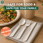 Styled table scene showing white compostable fork, spoon and knife next to a salad and cup