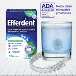 Efferdent box beside a glass of effervescing solution and a clear dental aligner, with ADA Accepted logo visible.