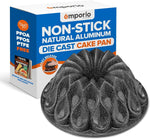 Emporio black marble-coated fluted flower-shaped nonstick die-cast cake pan with packaging box behind it