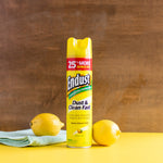 Centered Endust lemon zest aerosol can standing on a yellow surface with lemons and a cloth against a wood backdrop