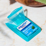 Close-up of a single turquoise Equate breath strips case with lid open and Fresh Mint label on a light marble surface.