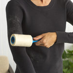 Person using an Evercare lint roller on a black sweater to remove visible pet hair and lint