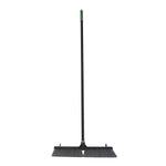 Full-length studio photo of a black push broom with green handle and 24-inch head