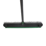 Overhead view of push broom showing bristles and green rubber squeegee strip on back edge