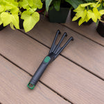 Expert Gardener poly cultivator laid on wooden decking near potted plants, showing full tool and handle detail.