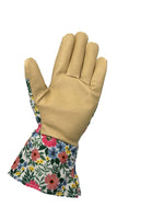 Palm-side view of a tan leather gardening glove with floral fabric cuff and back