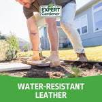 Lifestyle image of a person wearing Expert Gardener leather gloves kneeling outdoors while positioning a stone paver in a garden setting.