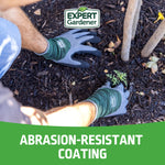 Hands wearing Expert Gardener gloves planting a small seedling in mulch, brand logo above