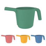 Front perspective render of green ribbed watering can with smaller color swatches of coral, yellow, and blue below.