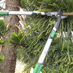 Close action view of extendable lopper slicing a branch, showing the blade and telescoping handle
