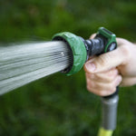 Close lifestyle image of the garden nozzle producing a focused spray while held over grass