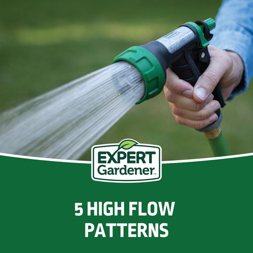Close-up of a green-and-black handheld watering nozzle spraying a strong stream, Expert Gardener logo and ‘5 HIGH FLOW PATTERNS’ banner visible