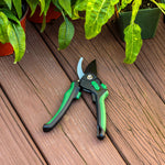 Expert Gardener bypass pruner placed on a wooden deck among potted plants, showing full tool and blade.