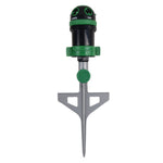 Top-forward view of a green and black gear-drive spike sprinkler showing control ring and stake