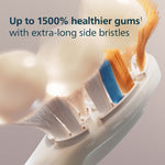 Detailed close-up of Philips Sonicare brush head showing extra-long side bristles in orange and blue with text about healthier gums.